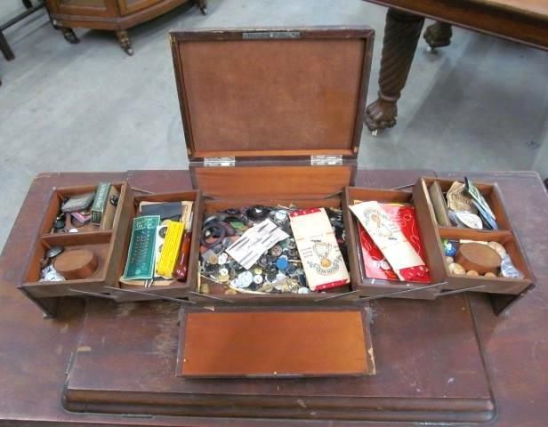 Open wooden sewing box with various compartments.