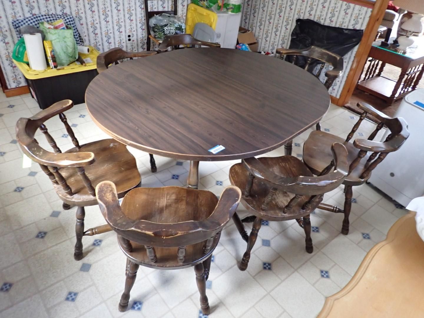 Round wooden dining table with four matching chairs in a room.