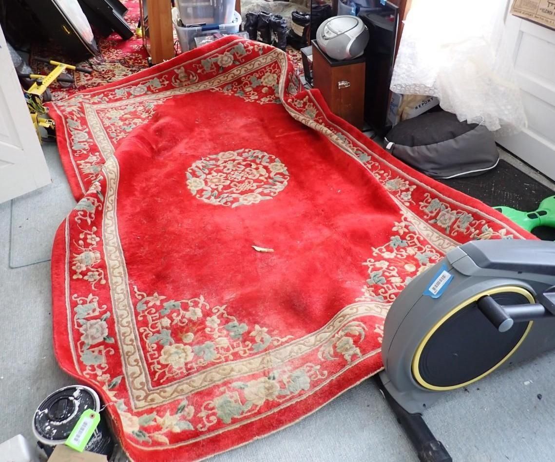 A red, rectangular, traditional-style area rug with a central medallion and ornate border.