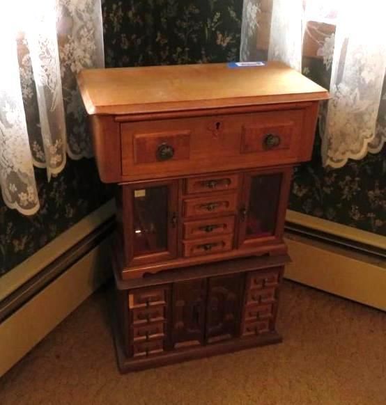 Wooden jewelry cabinet with multiple drawers and compartments, stacked in three sections.
