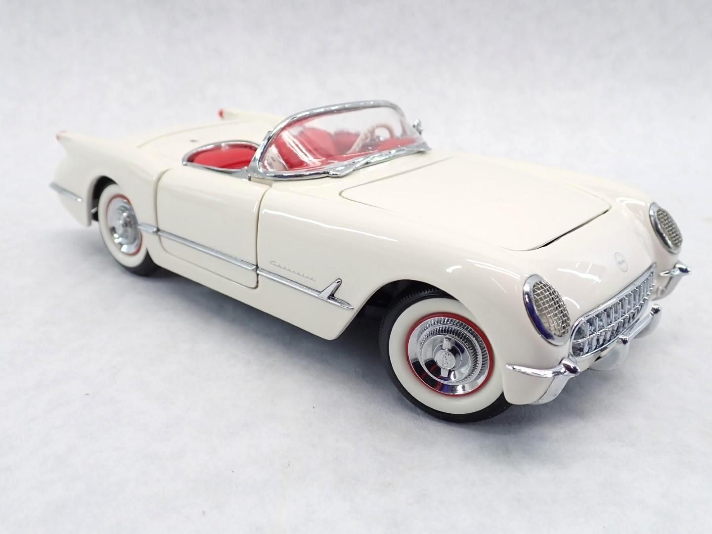 Cream-colored classic convertible car with red interior. Chrome accents and whitewall tires.