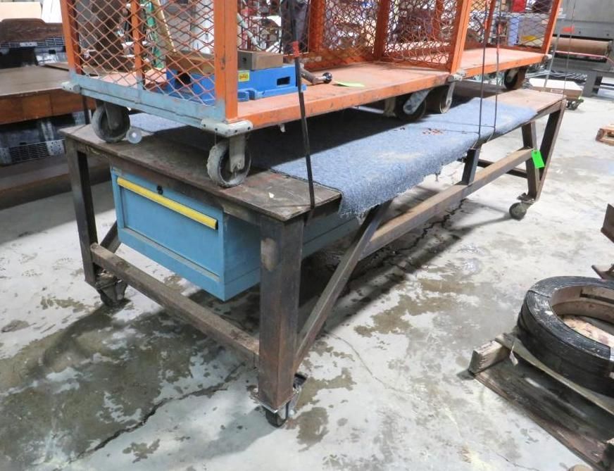 Rolling workbench with a blue cabinet and an orange cart on top, in a workshop setting.