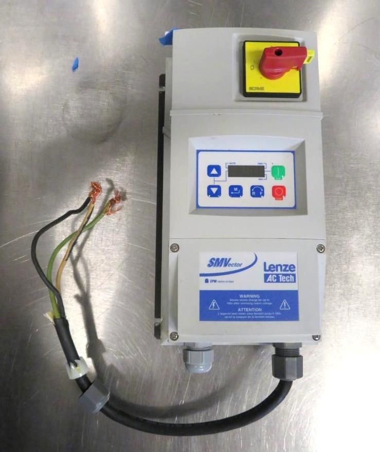 Gray control panel with digital display and red and yellow switches, mounted on a stainless steel surface.