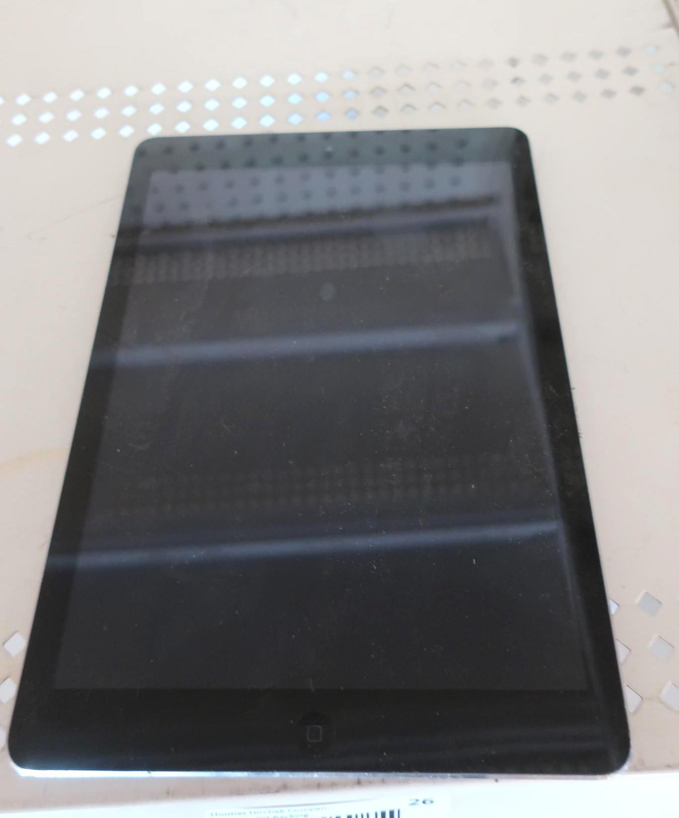 Black tablet lying on a light-colored surface.