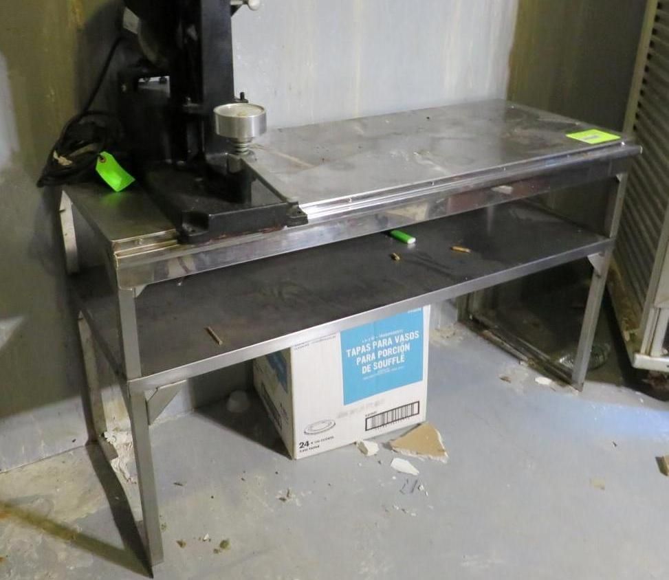 Stainless steel work table with a press machine, a shelf, and a box.
