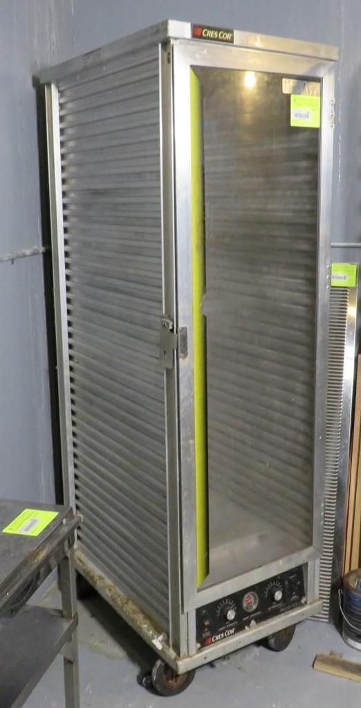 Stainless steel food warmer cabinet on wheels, vertical, with slotted shelving and a glass door.