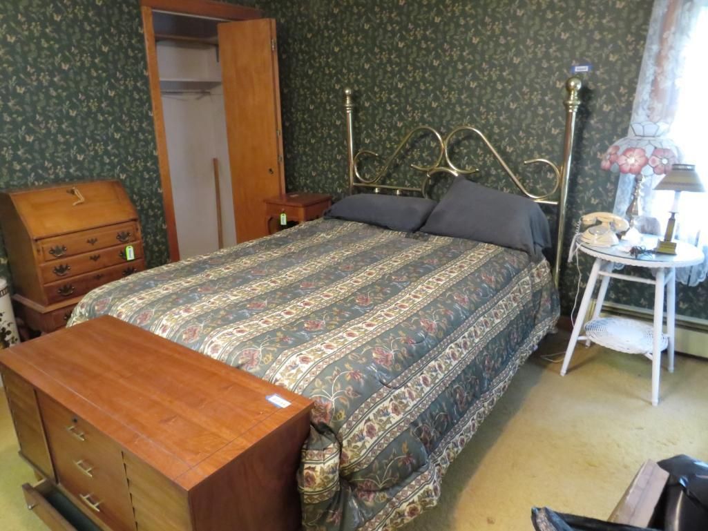 Bedroom with brass bed, floral wallpaper, wooden furniture, and a lamp.