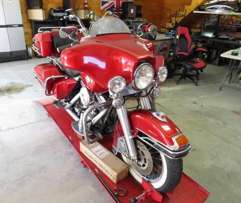 Red Harley-Davidson motorcycle on a lift in a garage.