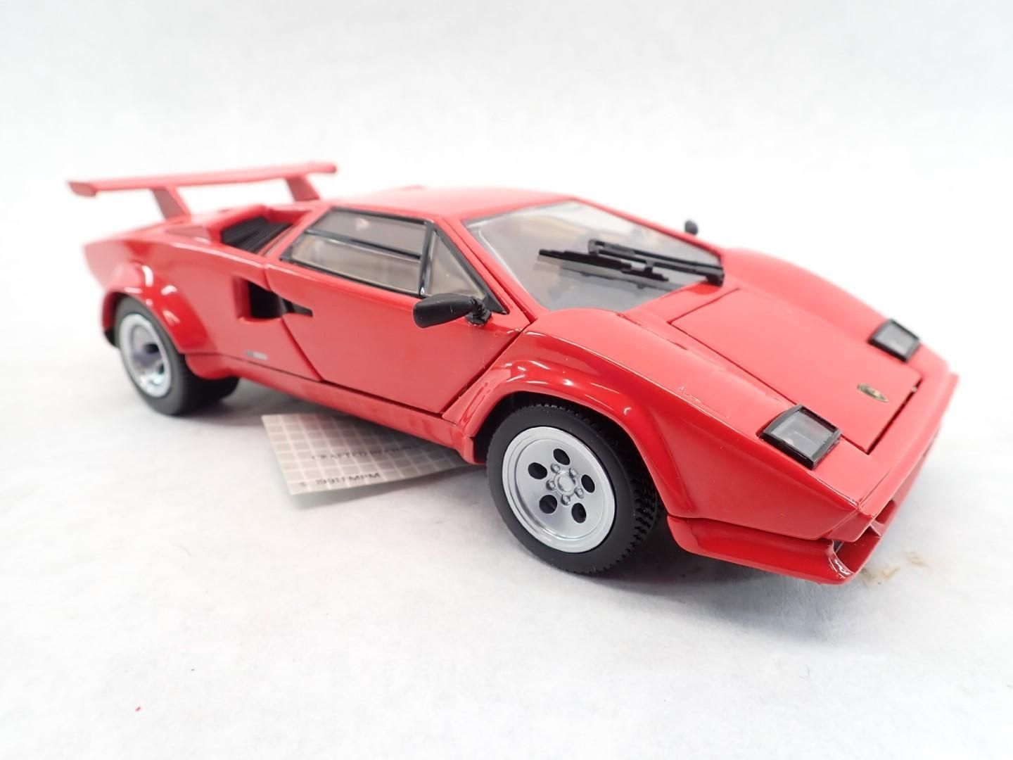 Red Lamborghini Countach sports car model, on a white surface.