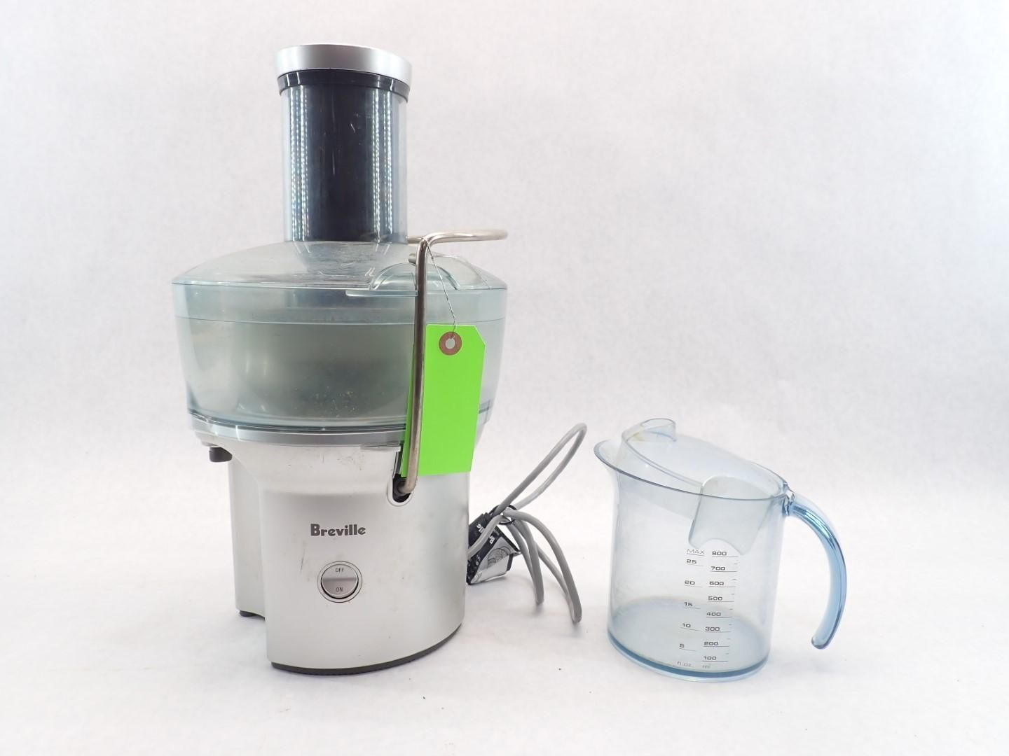 Silver Breville juicer with a measuring pitcher on a white background.