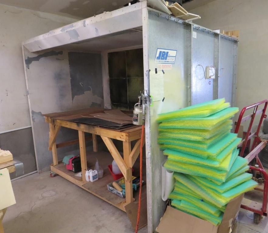 Spray booth with a wooden worktable, paint supply.