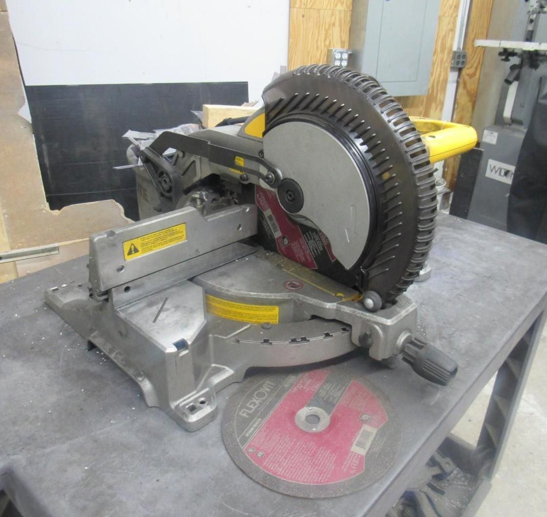 Miter saw on a workbench with a blade and yellow accents.