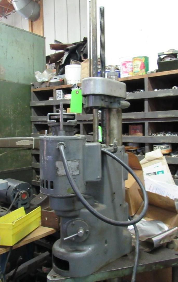 Gray vertical spindle machine with a motor, in a workshop setting.