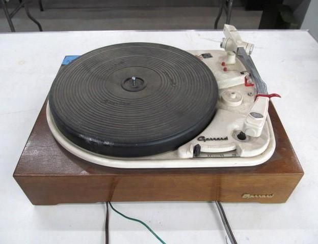 Vintage Garrard turntable on a wooden base with a black platter and white components.