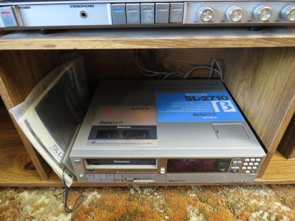 Silver Technics SL-2700 turntable in a wooden cabinet, above an audio receiver.