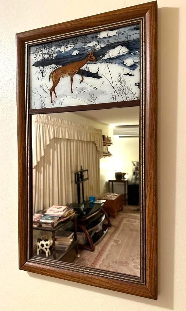 Mirror with deer artwork above.