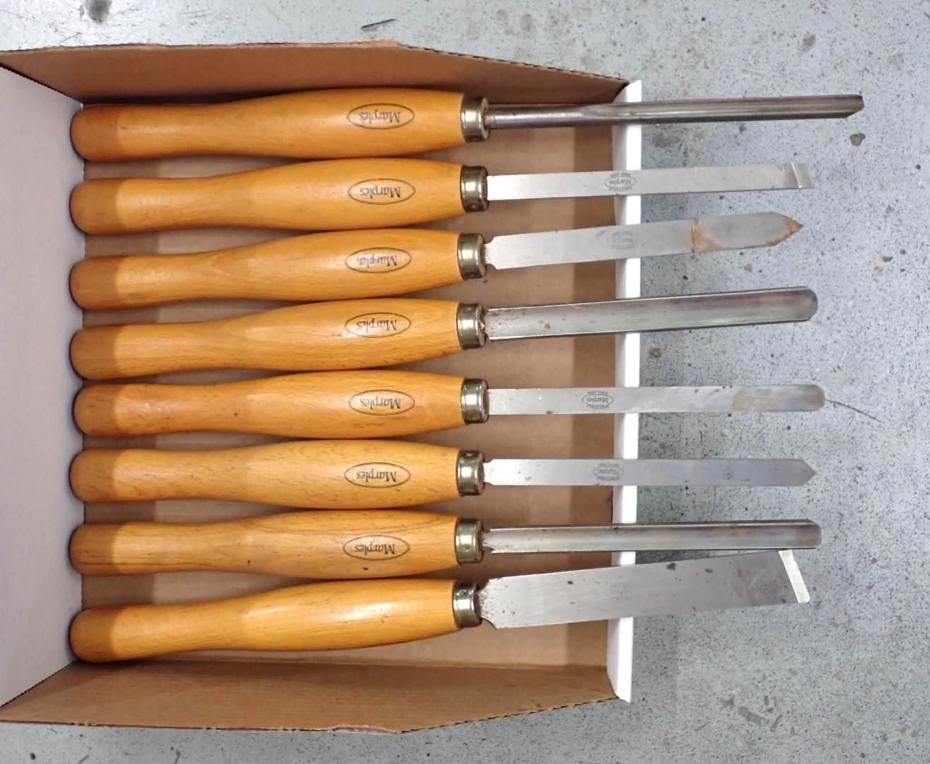 Set of wood turning chisels with wooden handles in a cardboard box.