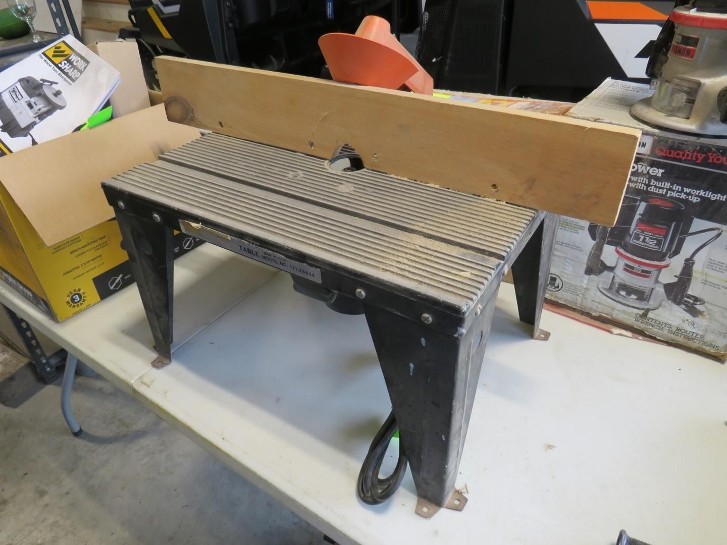 Router table with wooden fence on a white table.