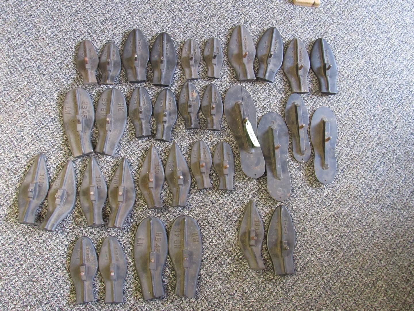 A collection of dark grey, petal-shaped objects arranged on a textured, grey surface.