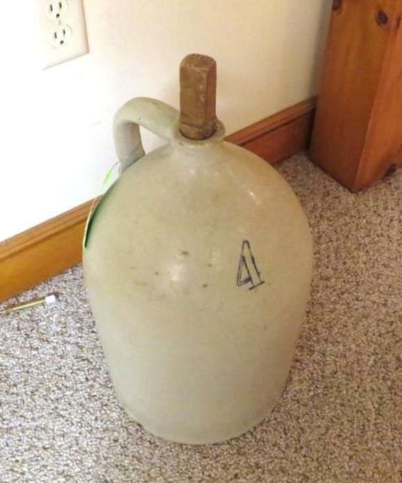 A stoneware jug with a handle and cork, marked with the number