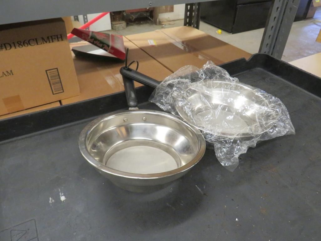 Two stainless steel bowls on a black surface. One is wrapped in plastic.