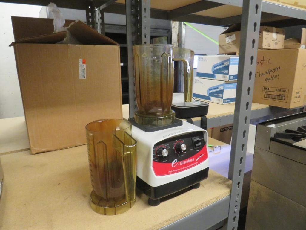 Blender with spare pitcher, and boxes on a shelf.