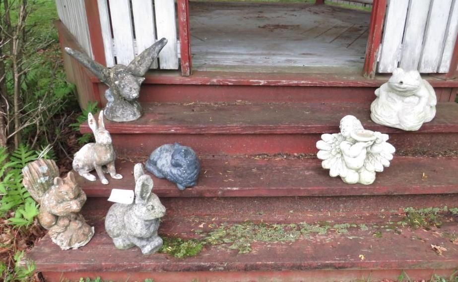 Garden statues of various animals on red porch steps.