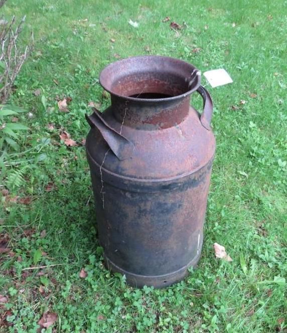 Metal milk can on grass.
