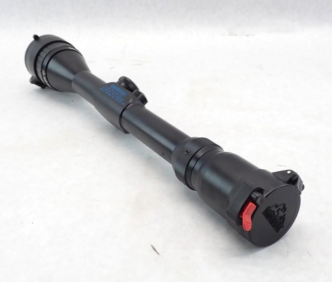 Black scope with red button, shown on a white background