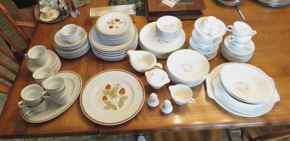 Table setting with floral patterned plates, cups, and serving dishes.