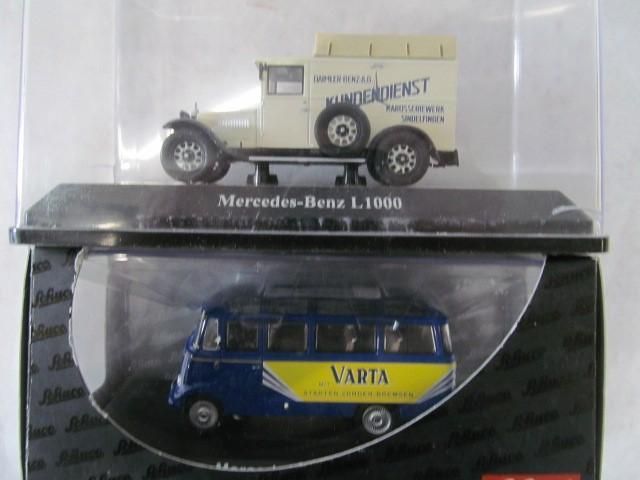 Two miniature Mercedes-Benz vehicle models: a beige truck and a blue Varta bus, in their display cases.