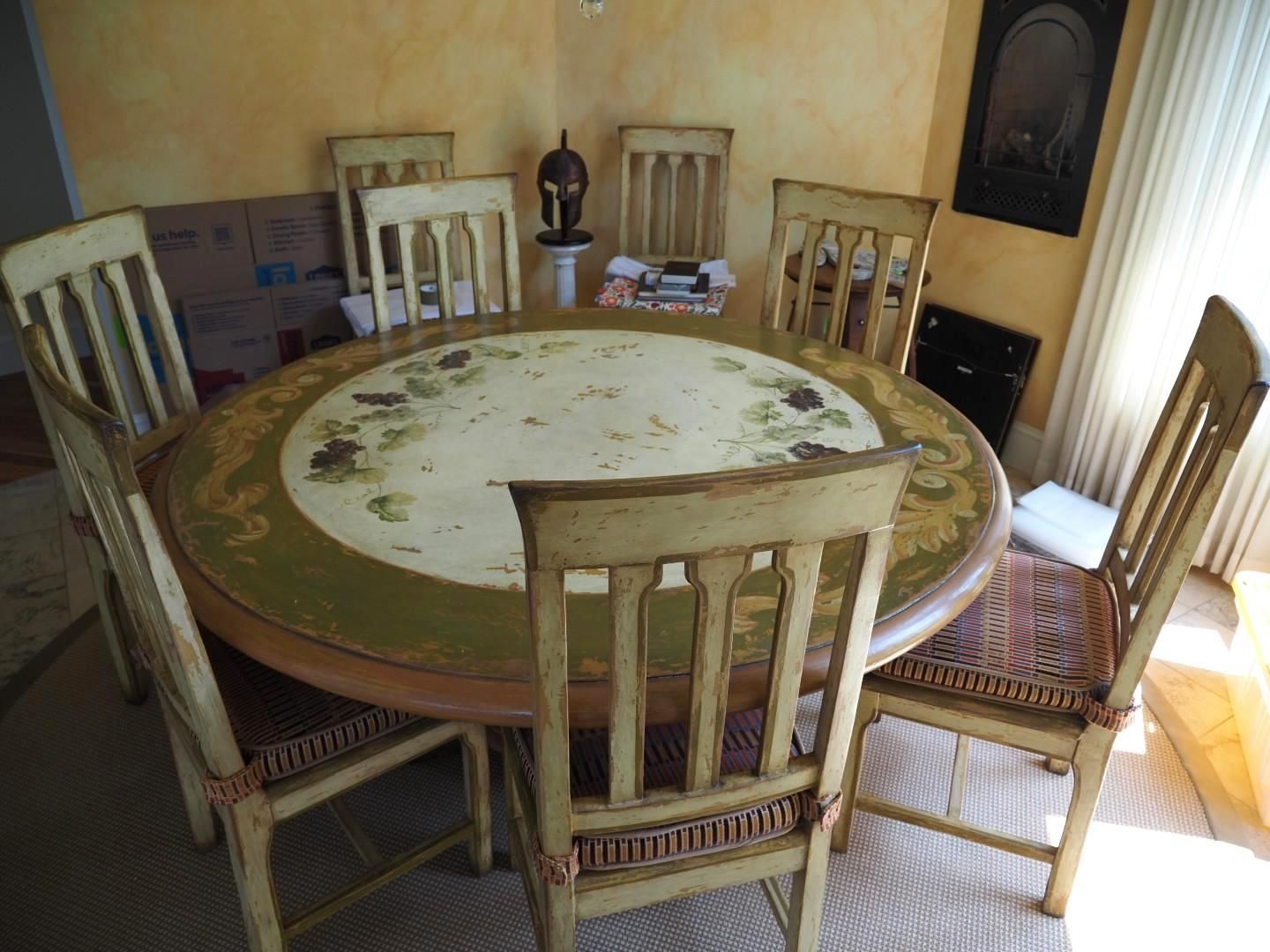 Round dining table with six chairs, cream and green colors.