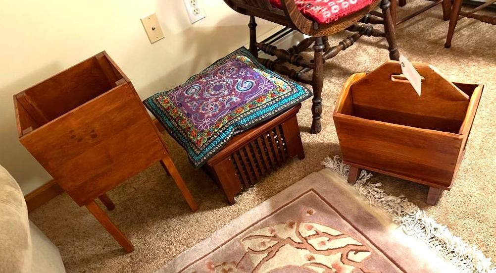 Wooden furniture: a plant stand, a footstool with a patterned pillow, and a magazine rack.