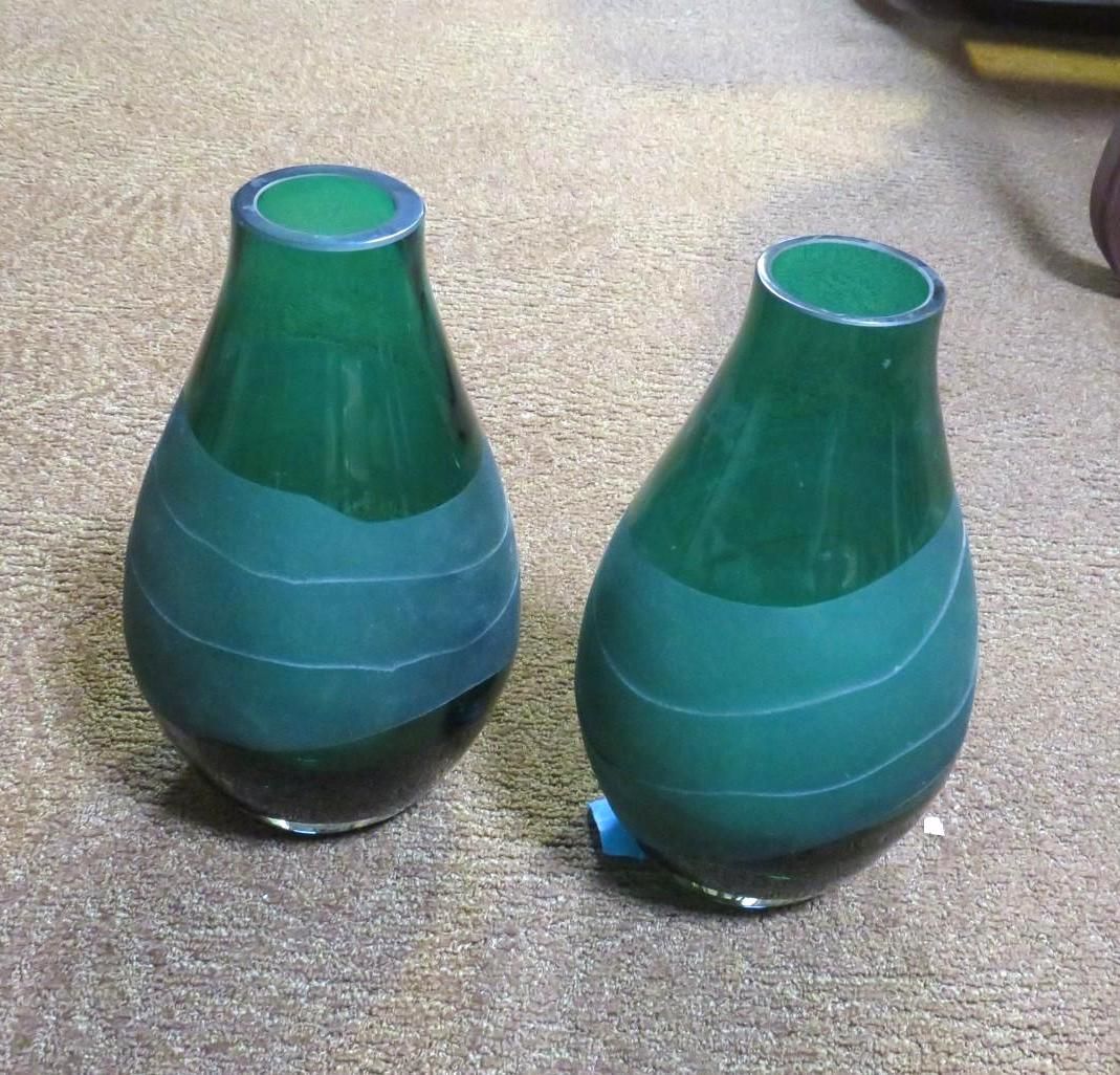 Two green glass vases with light blue stripes.