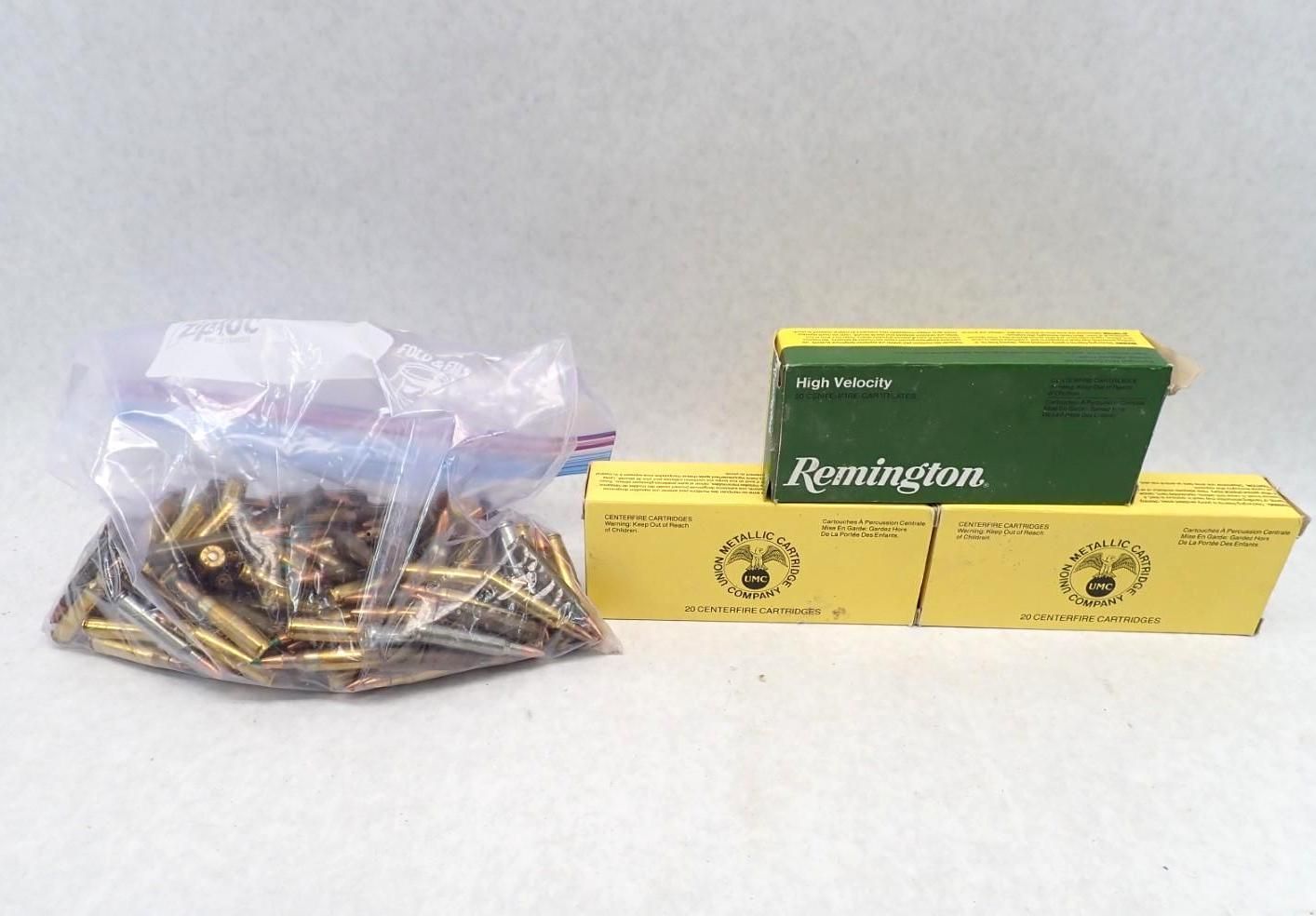 A clear plastic bag and three boxes of ammunition. The bag contains many loose bullets. Yellow and green boxes.