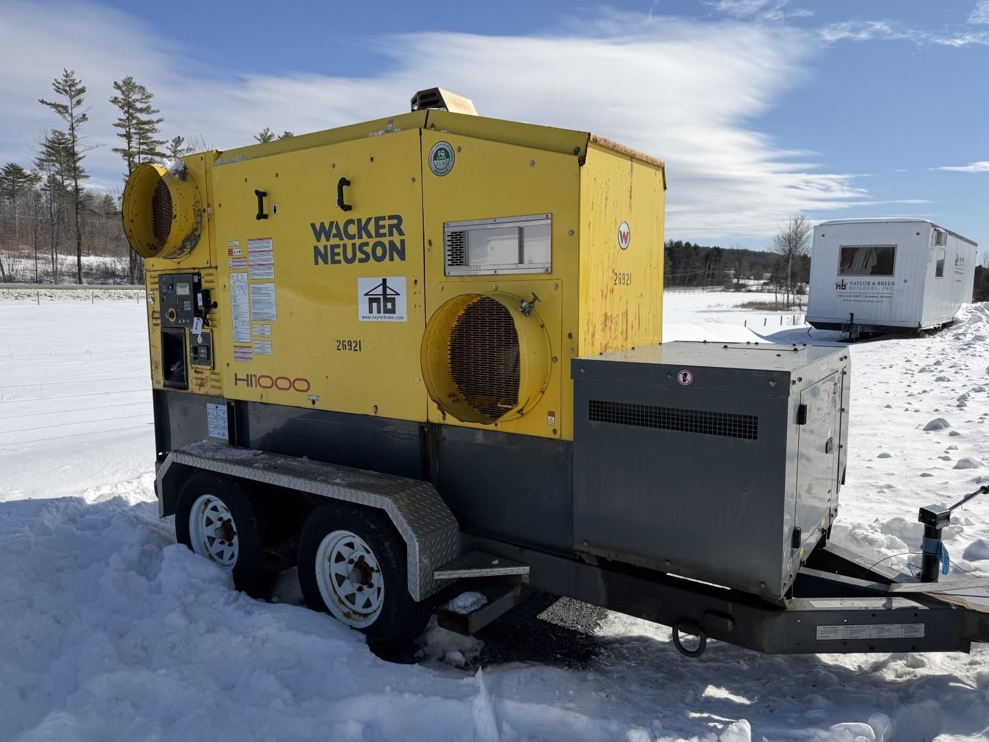 Yellow Wacker Neuson industrial heater on a trailer in a snowy field.