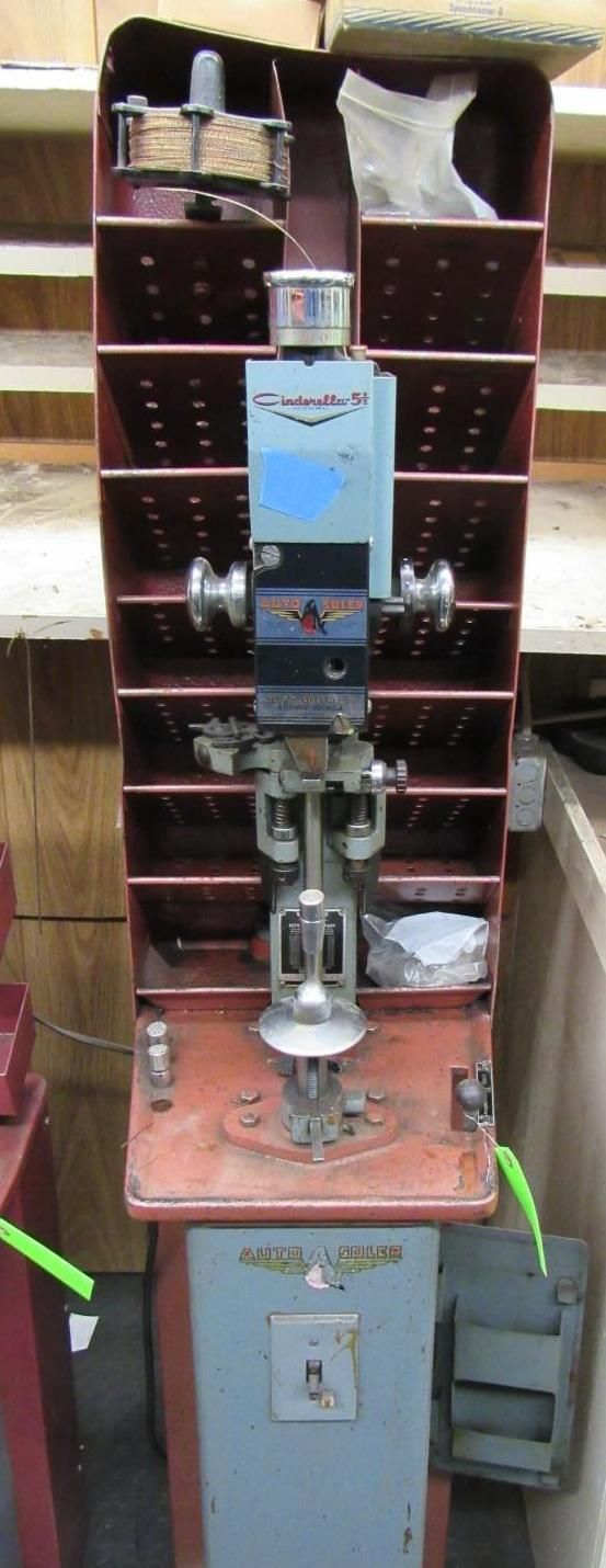 Industrial machine with red shelves and a mechanical component in a workshop.