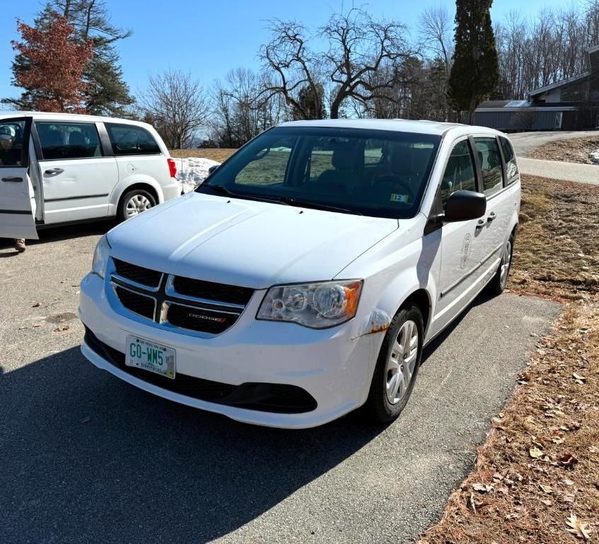 White Dodge Grand Caravan minivan parked on pavement.