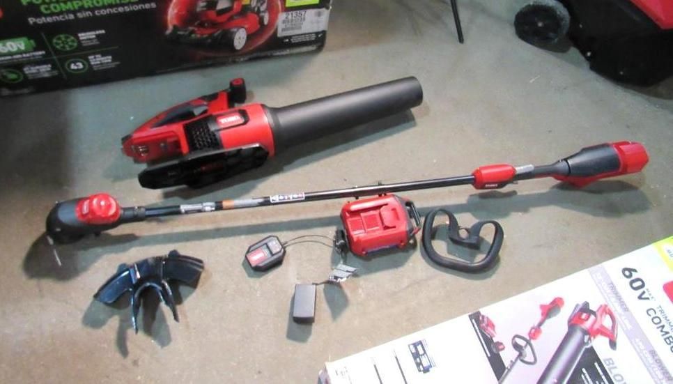 Red and black electric lawn tool set with blower, trimmer, battery, and charger.