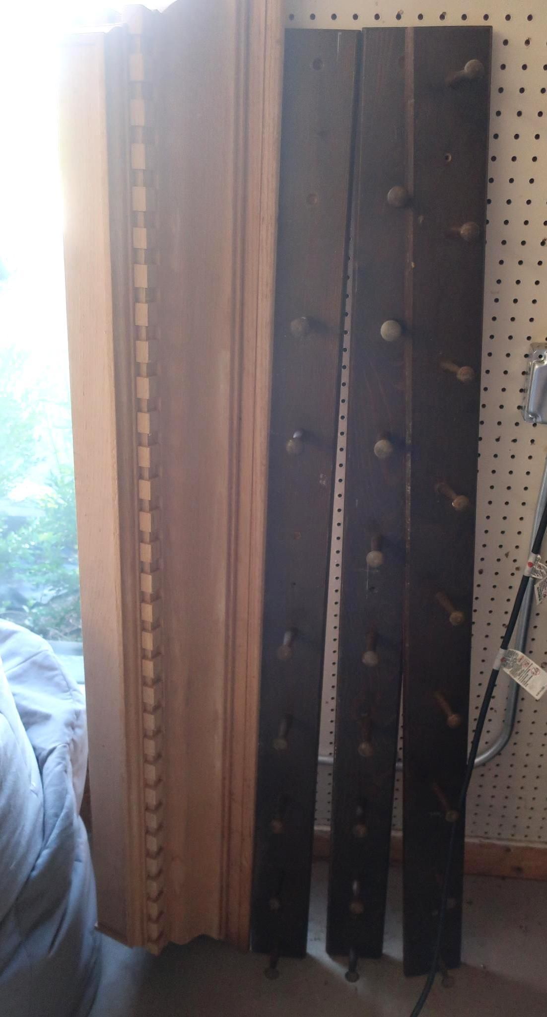 Three dark wooden boards with circular holes.