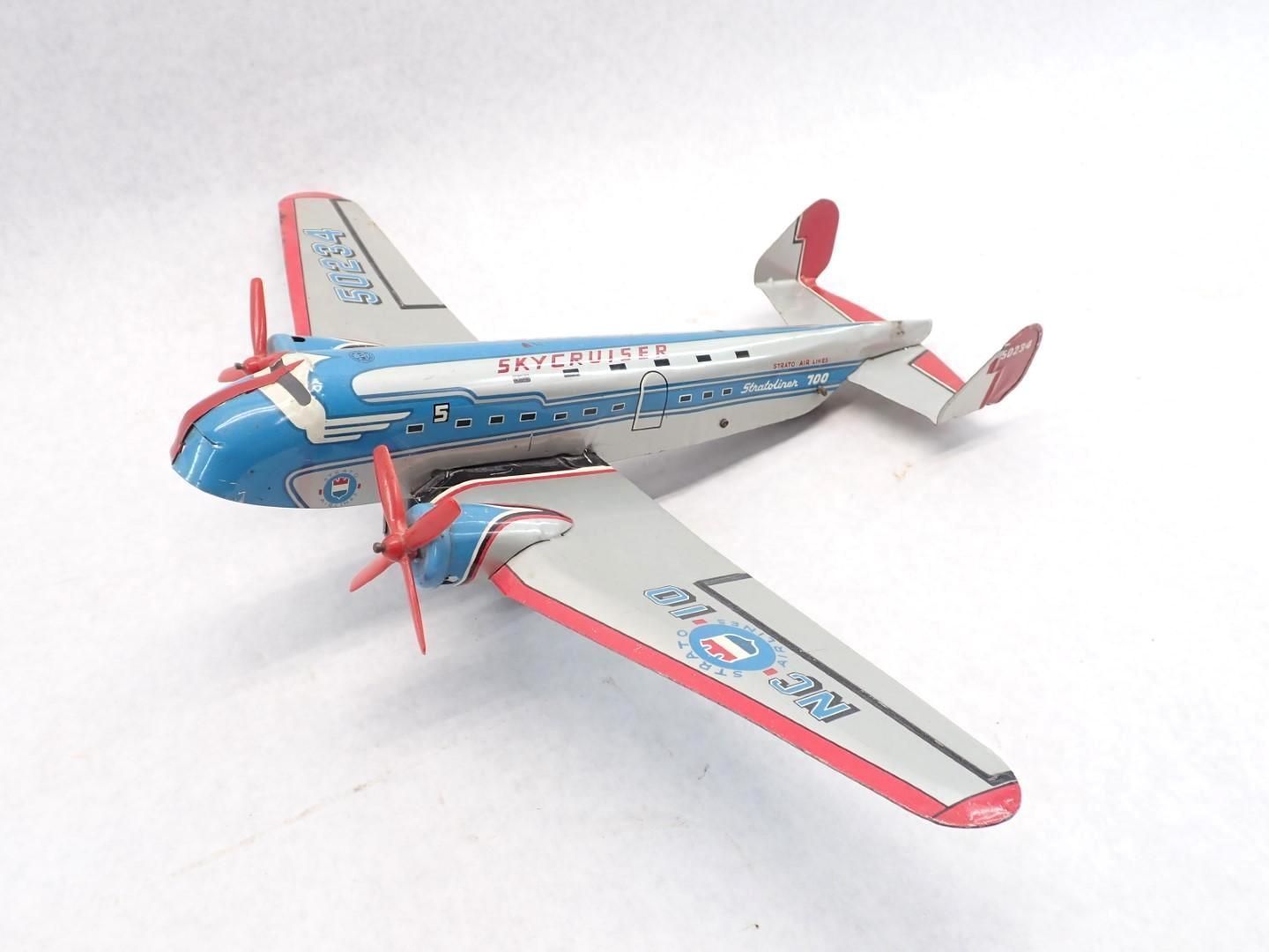 Toy airplane, blue and silver, with red accents. Propellers, wings, and a tail.