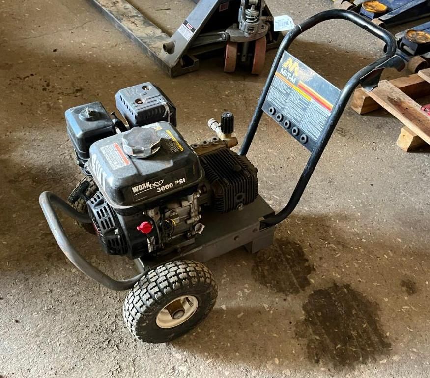Pressure washer on wheels, black and gray with a black handle and a red knob.