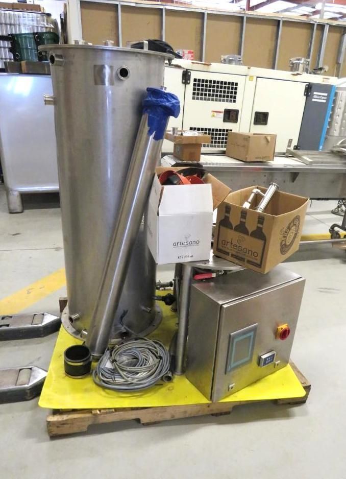Stainless steel industrial tank with control panel and associated parts on a yellow pallet.