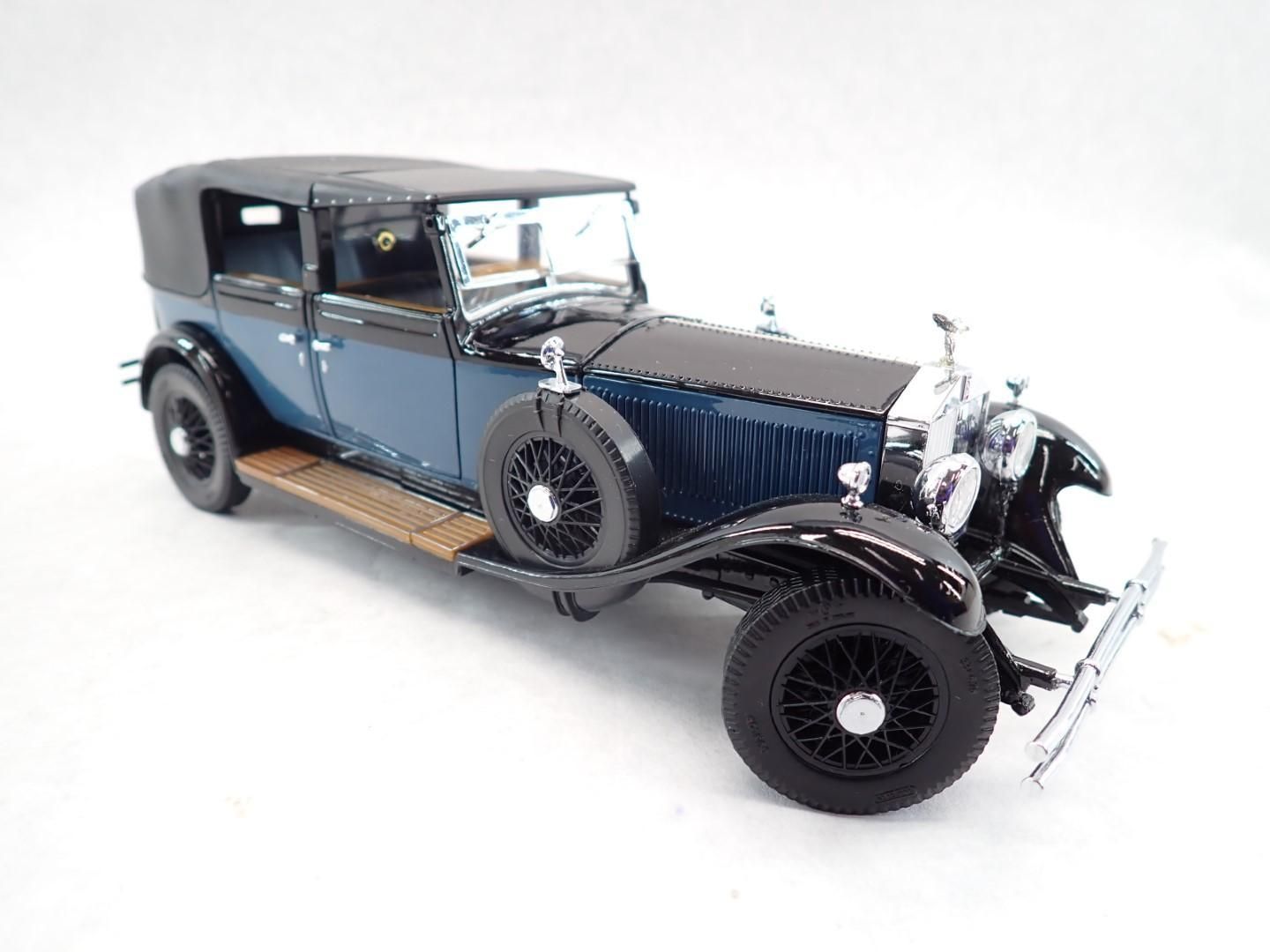 Blue and black Rolls-Royce model car on a white background.