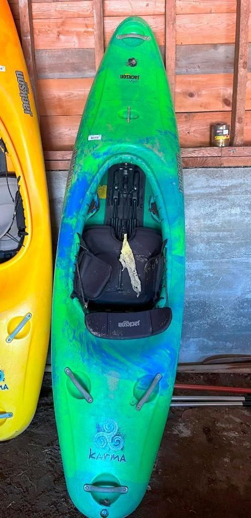 Green and blue kayak, with a black seat, next to a yellow kayak.