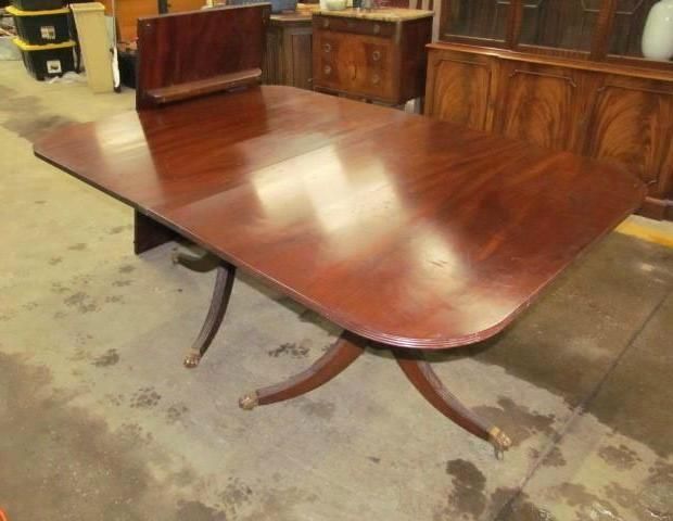 A large mahogany dining table with a leaf extended, indoors.