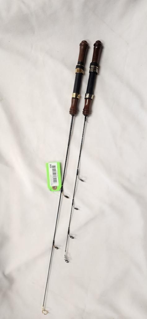 Two fishing rods with brown handles lie on a white fabric.