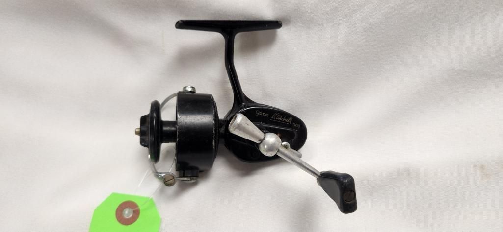 Black fishing reel on a white surface.