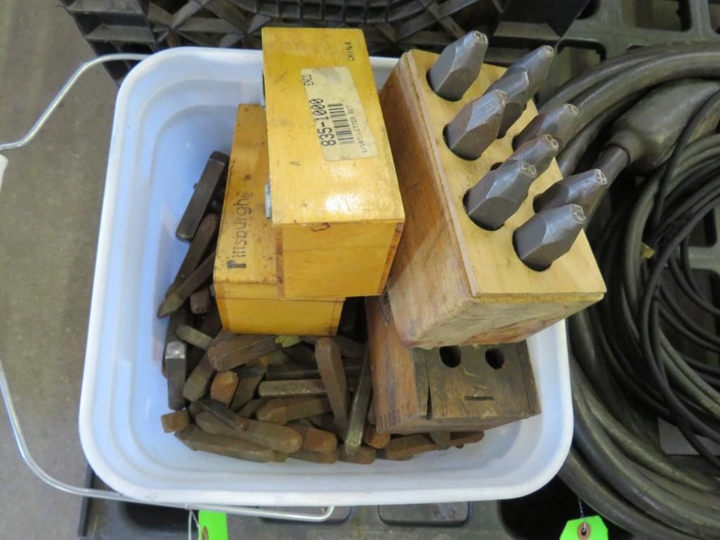 Bucket with tools: yellow boxes, bits in a wooden holder, and many metal pieces.
