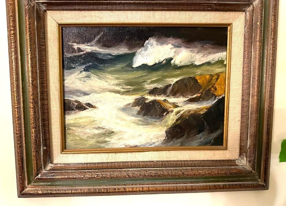 Oil painting of a stormy ocean with crashing waves and rocks. Dark sky and white foam. Framed.